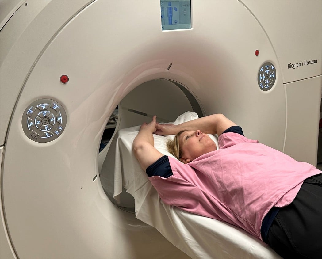 Woman laying in breast imaging machine called Cerianna